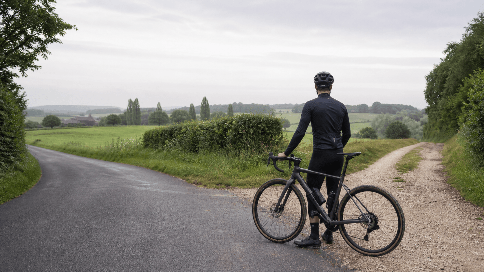 A drop-bar bike at the point where a paved country road becomes a gravel lane